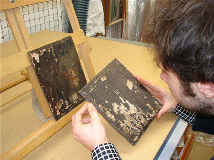 A researcher examines a painting