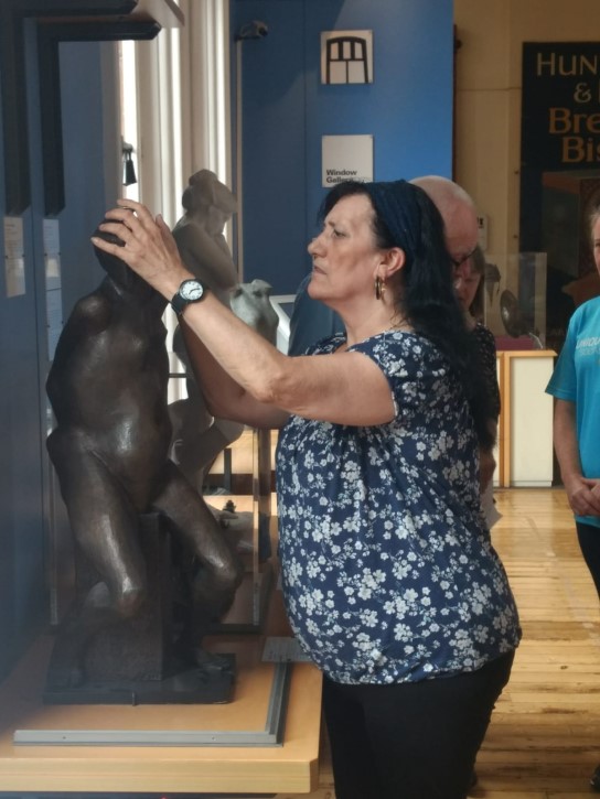 Participant touching the head of a sculpture