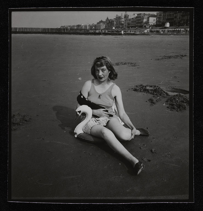 Photograph of Eileen Agar sitting on a beach with a plastic swan