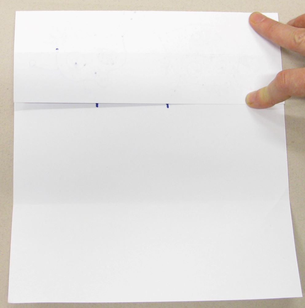 Fold the paper to hide your drawing of the body