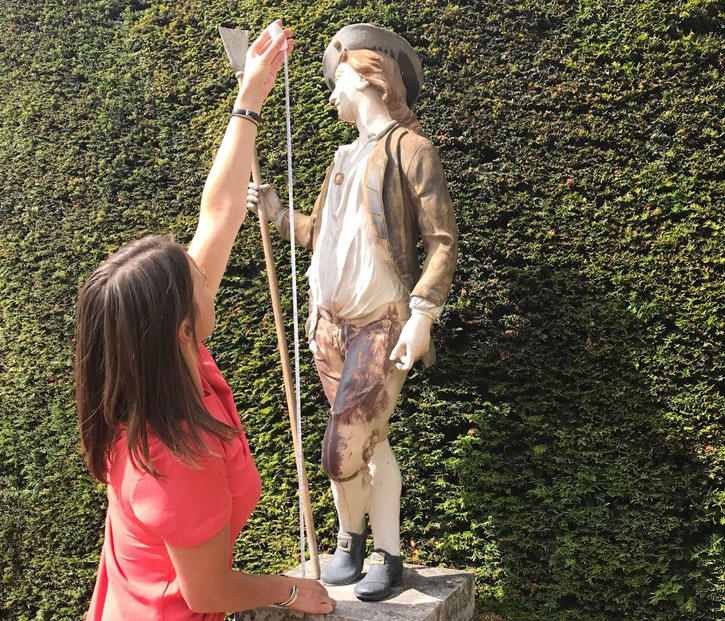 Coordinator Elizabeth Heath measures a sculpture during a photography session