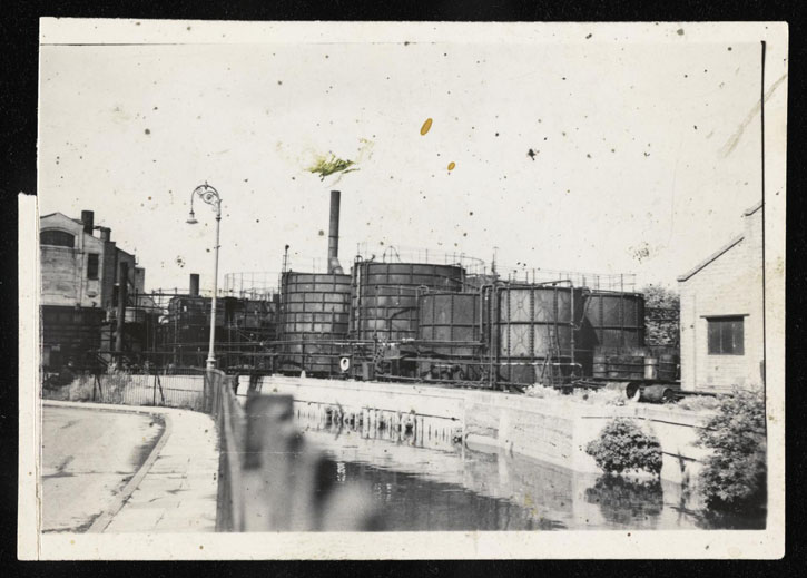 Black-and-white photograph of a canal and gas works