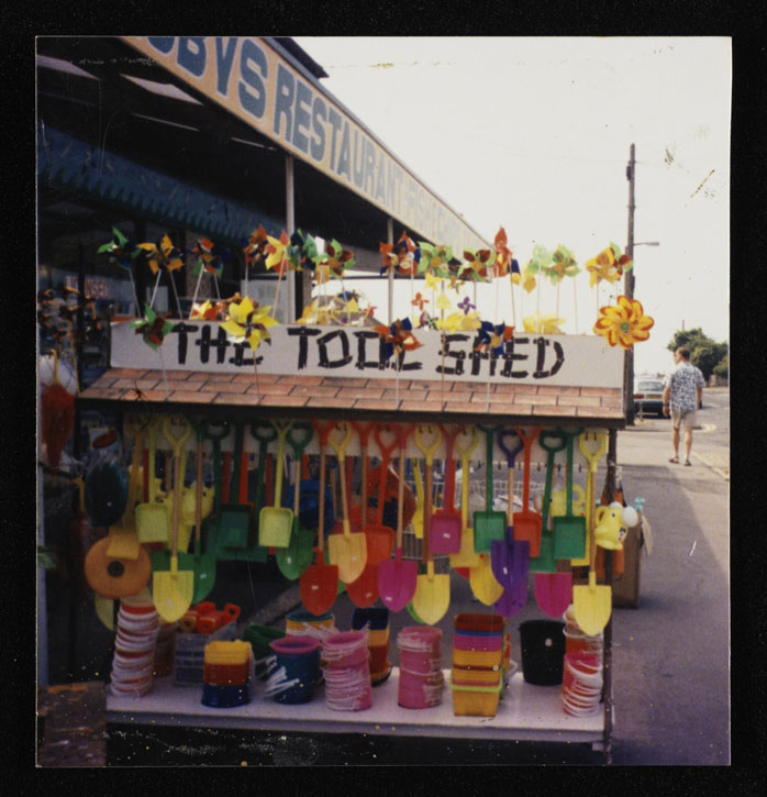 Colour photograph of a stall called 'The Tool Shed' selling plastic buckets and spades