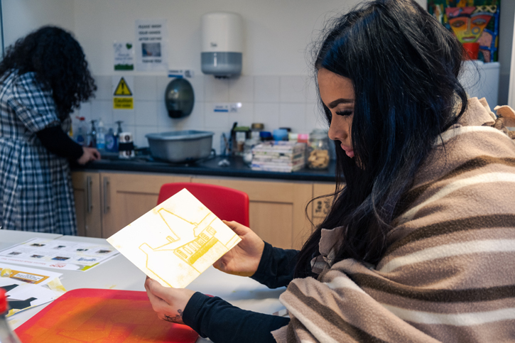 Pinc College student displaying a yellow monoprint based on the art of Maurice Wade