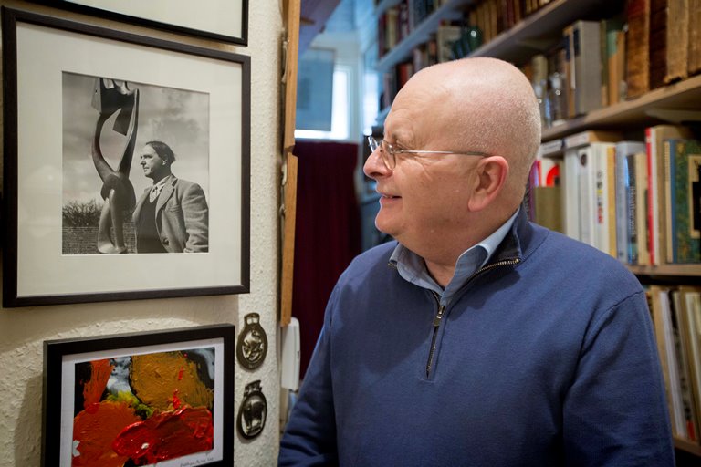 Tim Sayer in his London home, looking at a print of artist Henry Moore