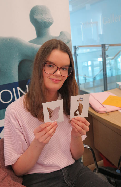 A Harlow College art student with her stencils of two cat sculptures in the library