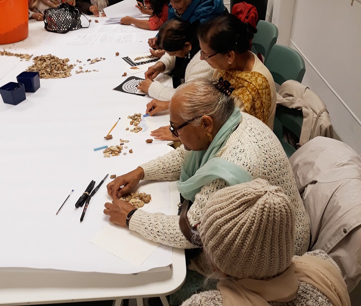 At Leeds Art Gallery a group of visitors create sculpture from stones during a VocalEyes workshop