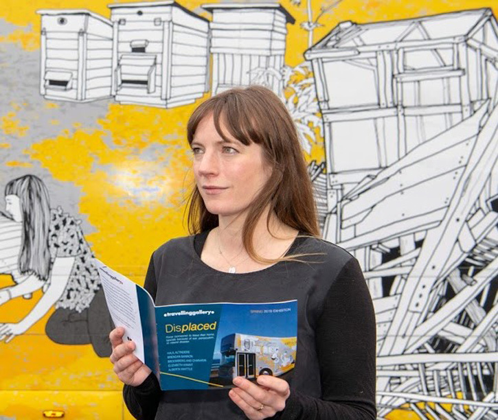 Curator Claire Craig in front of the Travelling Gallery ahead of the exhibition 'Displaced'