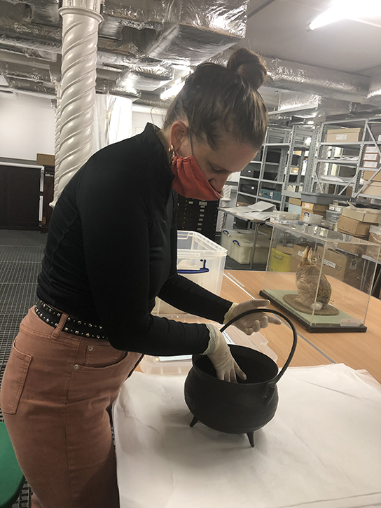 Florence Peake with Elizabeth Webb's cauldron in RAMM's store, 2020