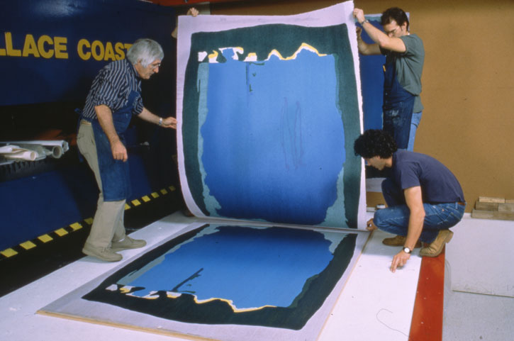 Kenneth Tyler, Robert Myer and Tom Strianese pulling proof impression from Helen Frankenthaler's 'Freefall' assembled woodblocks on hydraulic platen press in the workshop, Tyler Graphics Ltd., Mount Kisco, New York, 1992