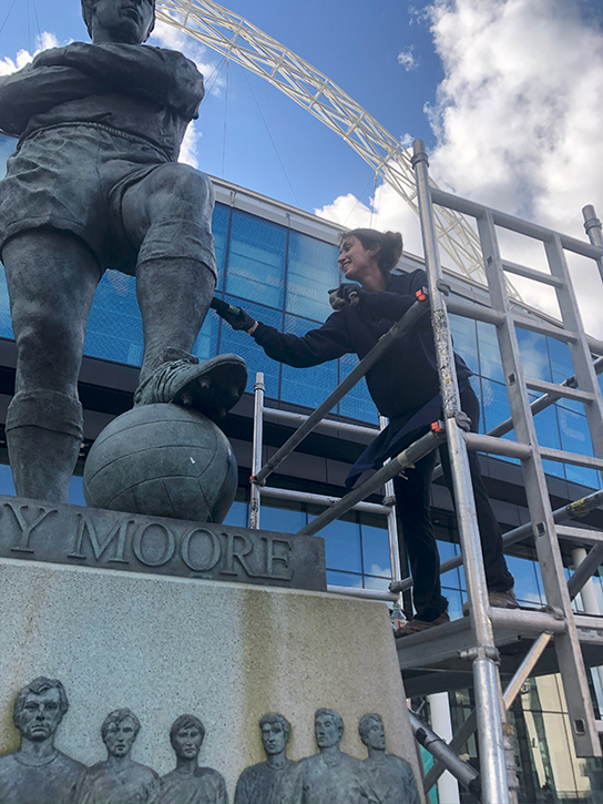 Lucy working on the sculpture of Bobby Moore at Wembley Stadium