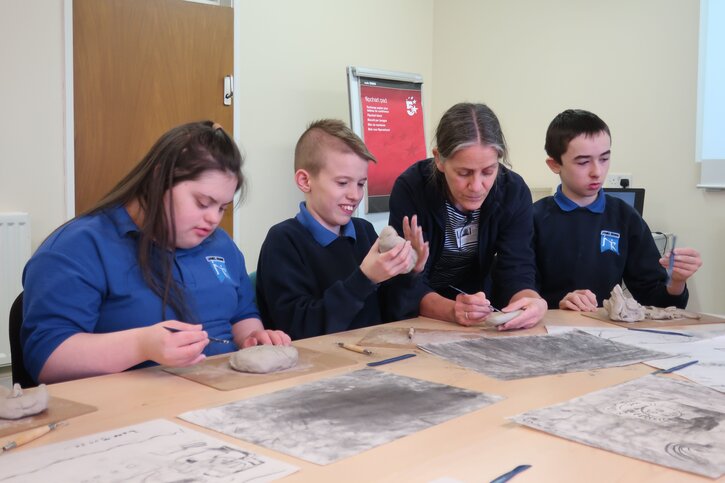 Pupils work with sculptor Shona Kinloch to create a relief in clay