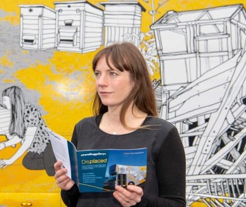 Curator Claire Craig in front of the Travelling Gallery ahead of the exhibition 'Displaced'
