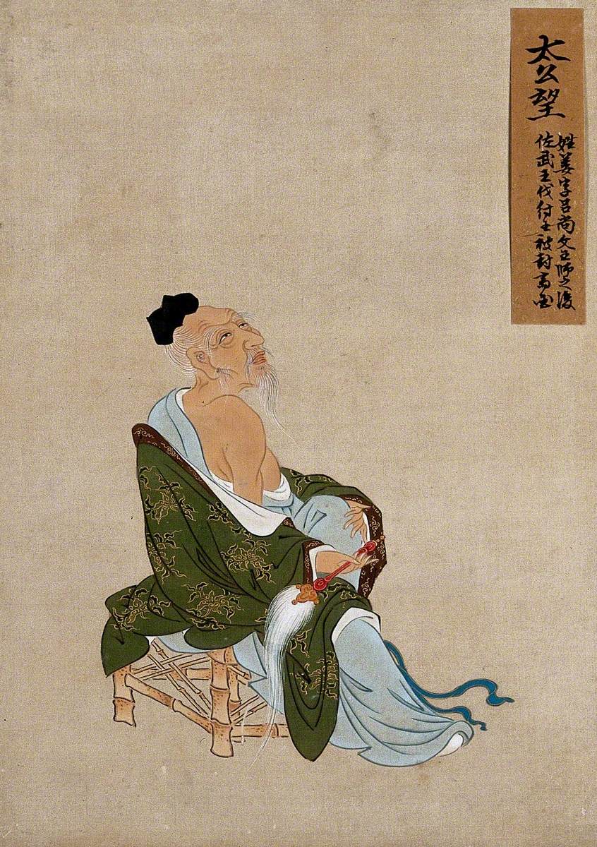 A Chinese Figure, Seated on a Bamboo Chair, Wearing Green Coloured Silk Robes with a Brown Border, Pictured with a Fly Whisk