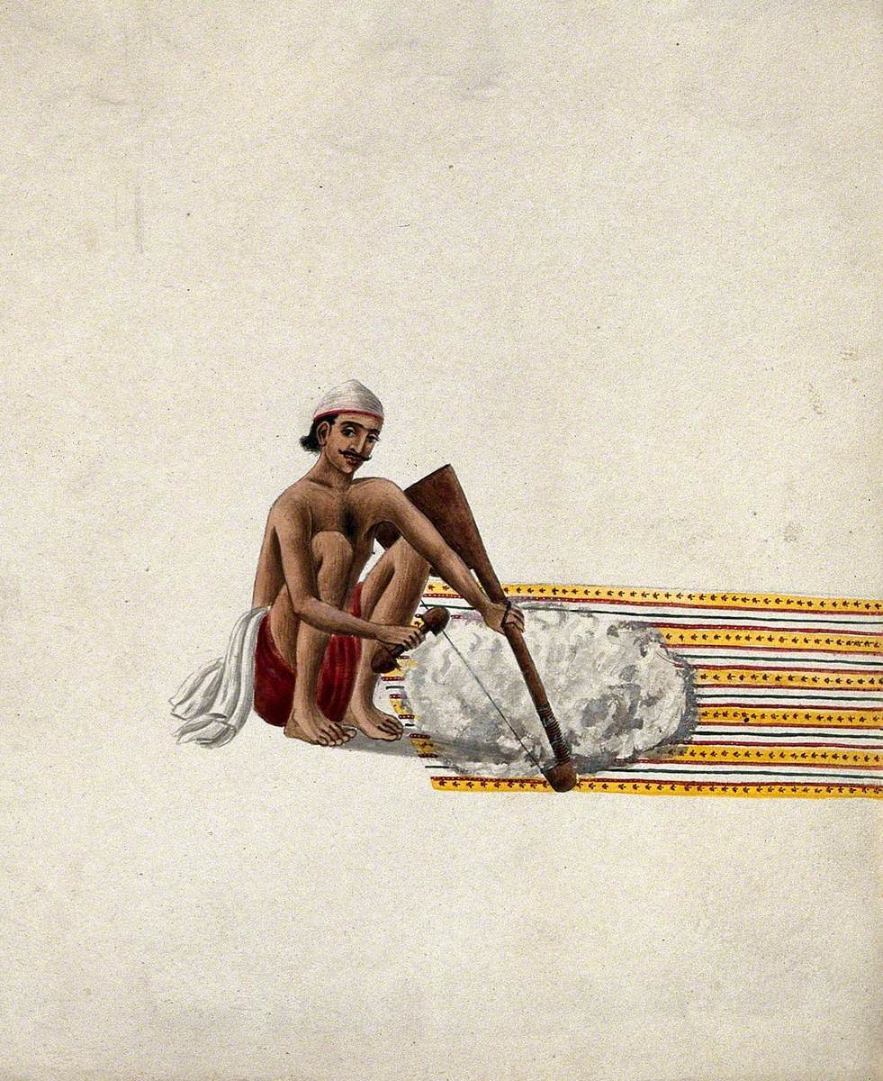 A Man Carding Cotton