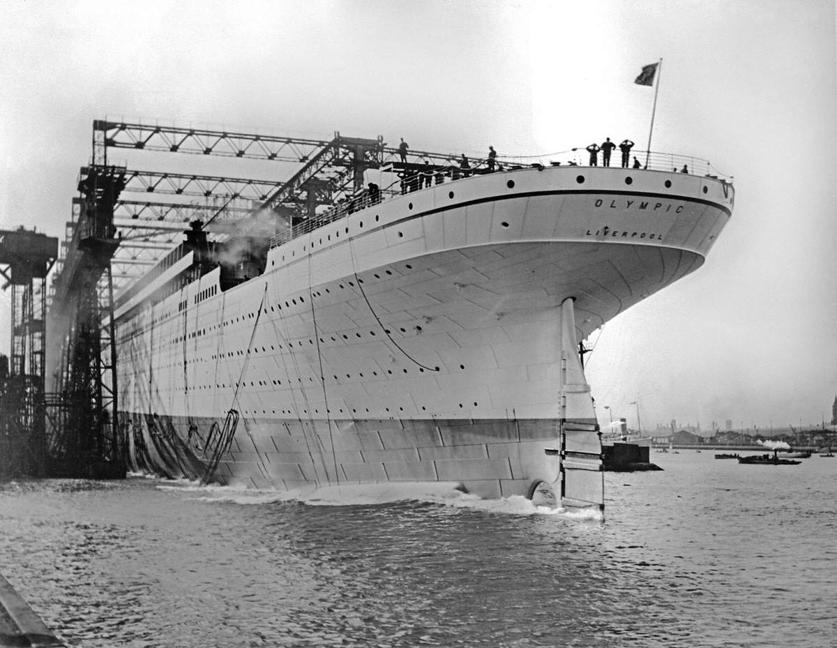 Launch; port stern view of light grey painted hull entering water