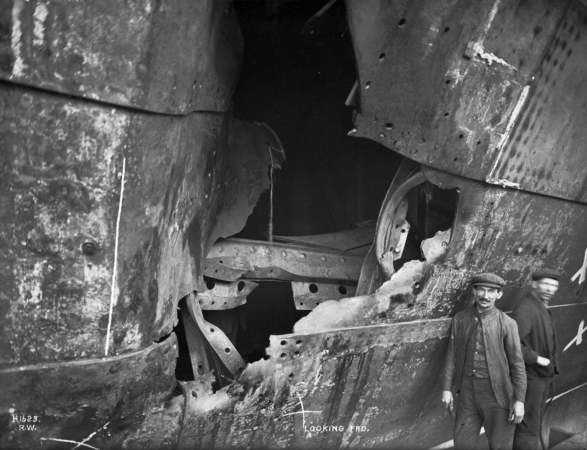 HMS 'Hawke' collision damage – middle hole looking forward, with two figures