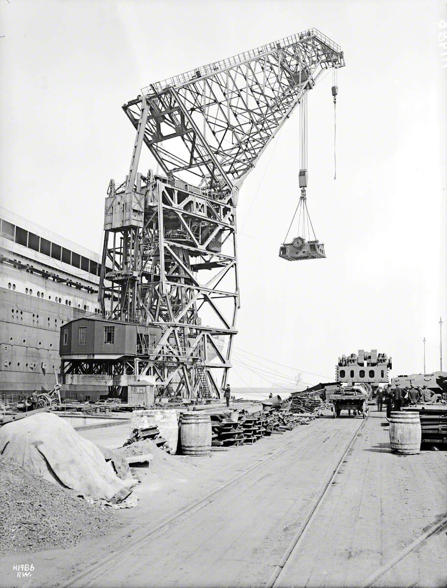 Engine bedplate being lifted from dockside by 200-ton floating crane