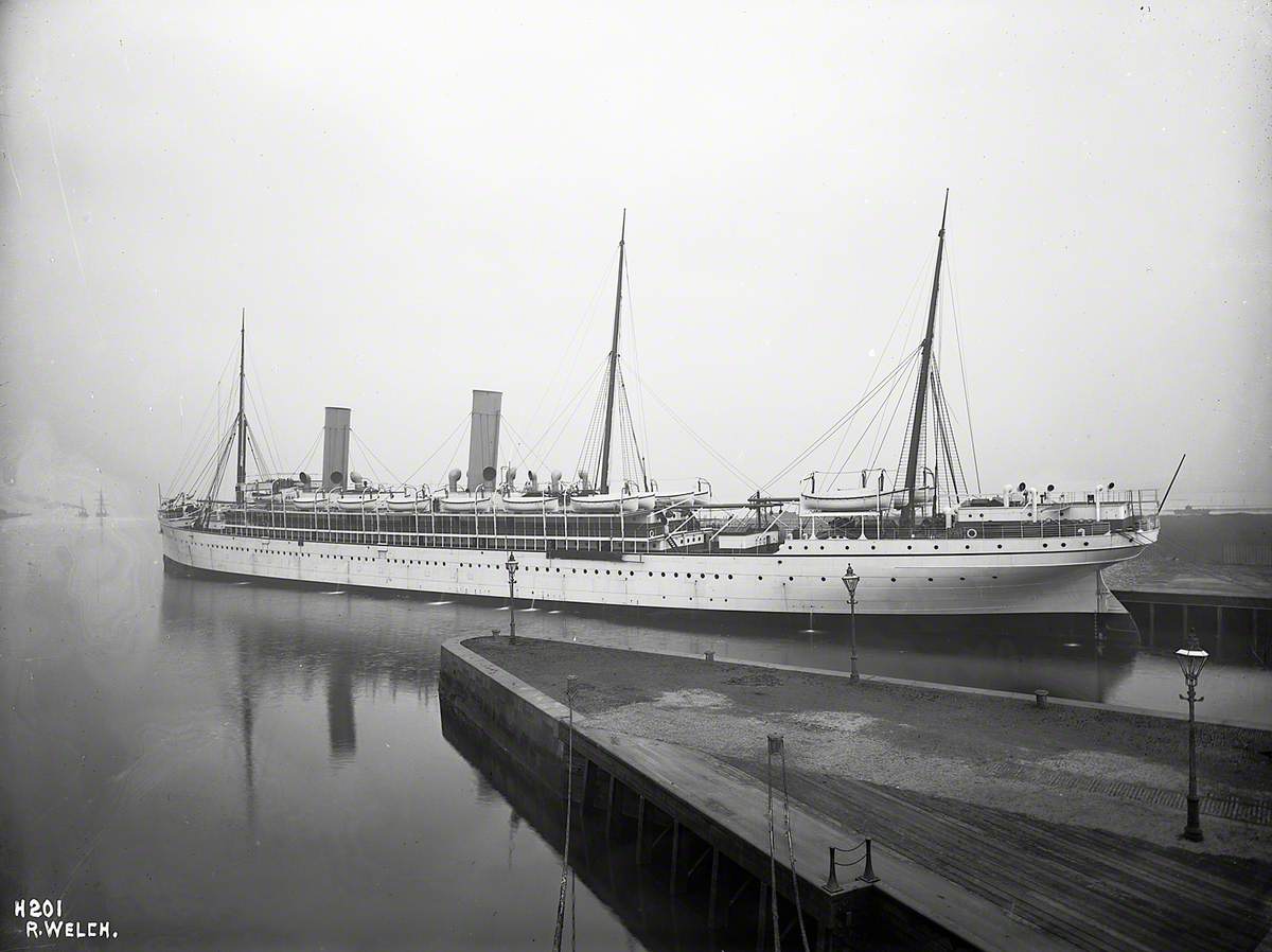 Port stern 3/4 profile of completed ship alongside wharf