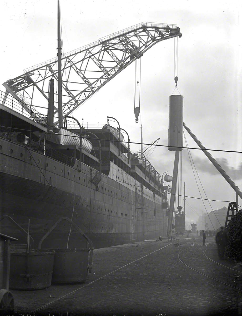 Engine bed and funnel being lifted on board by combination of folating crane and sheer legs