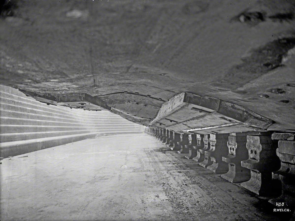 View of buckled plates on underside hull and temporary repairs, from floor of the dock