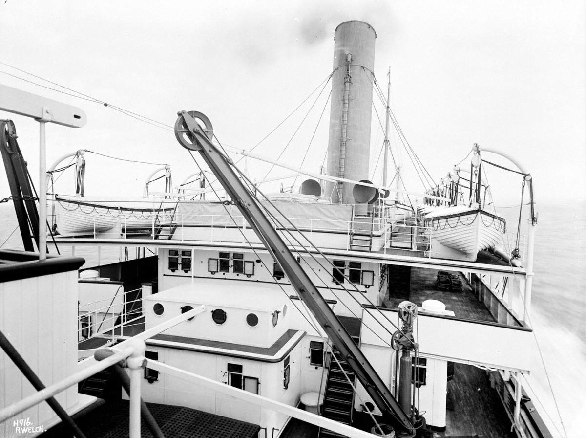 View aft from island bridge to passenger superstructure, promenade decks and funnel at sea