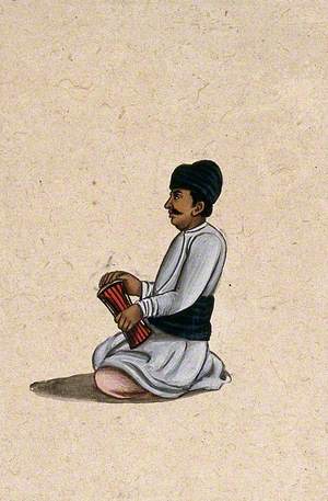 A Musician Holding an Indian Percussion Instrument