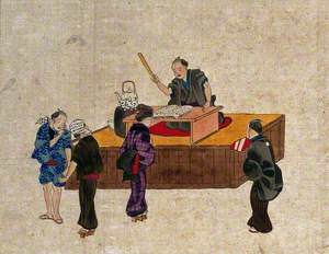 A Man Sits at a Table on a Platform Reciting from a Book while Three Women and a Man Stand Nearby