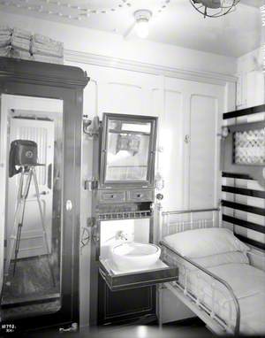First class single cot cabin B6, with camera reflected in wardrobe glass