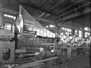 Rudder head mounted on lathe in engine works turning shop