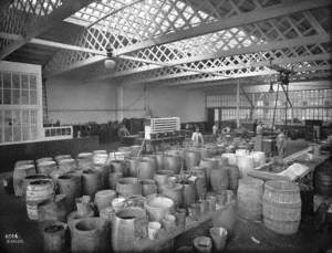Painter's shop interior with painters and barrels of paint