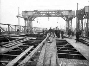 Laying upper deck plates, with posed workers