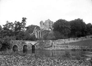 Untitled (a view of a stone arched bridge and ruined abbey behind)