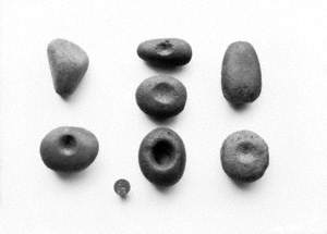 Untitled (a view of stone lammers against a white background, with an old penny for scale)