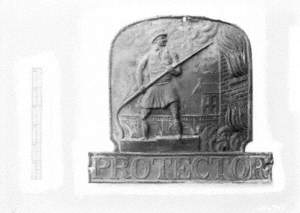 Untitled (a view of a fireman plaque entitled 'Protector' on a white background with scale)