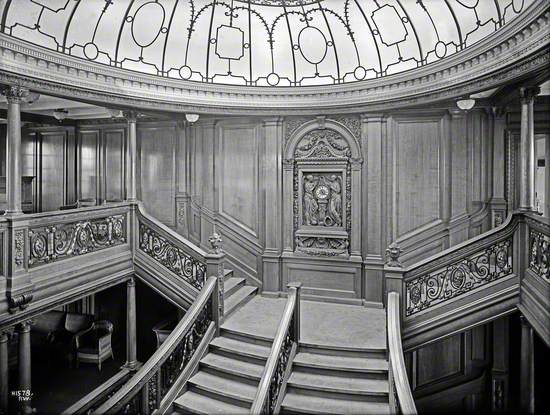 General view of first class main staircase, including landing, clock and part of dome