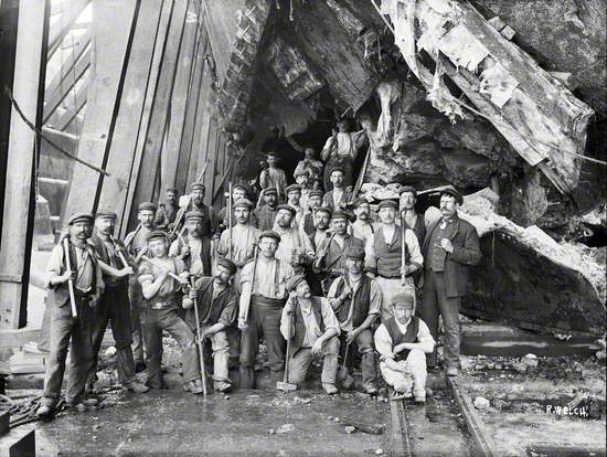 The 'Black Squad' posed beneath the damaged section of hull
