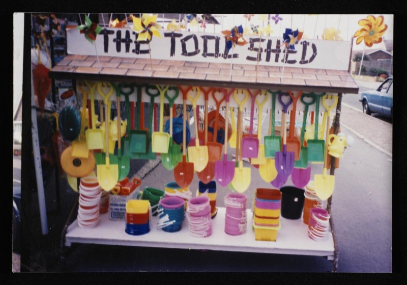 Colour photograph of a stall called 'The Tool Shed' selling plastic buckets and spades