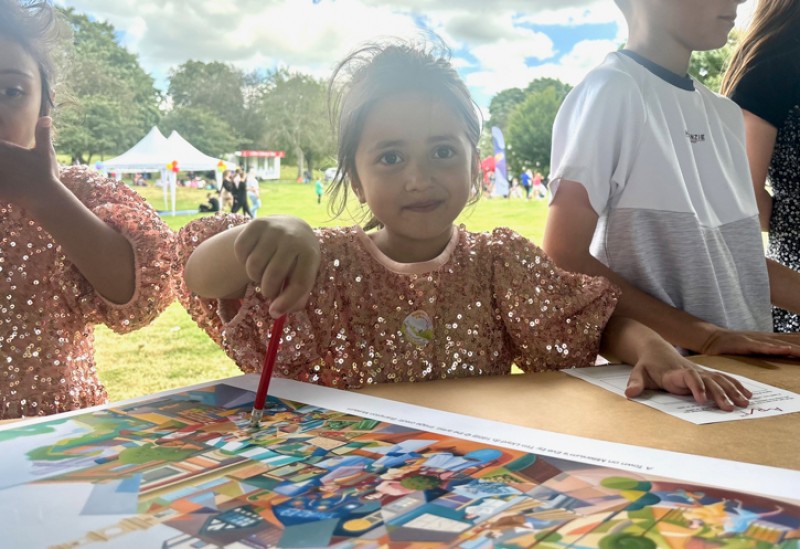 Young people looking closely at an artwork and pointing out things they can see