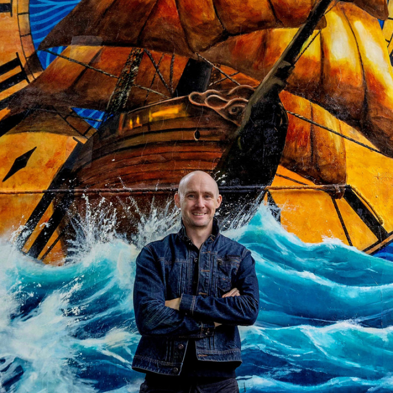Artist Paul Curtis in front of one of his murals