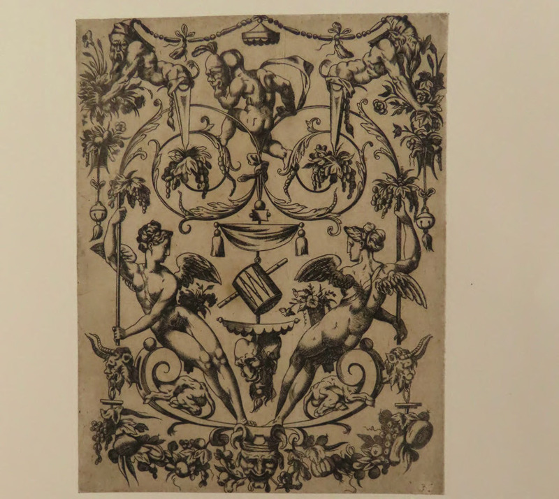 Ornamental design with two winged figures on a double volute, holding up leaf vines, on which a child is seen on the back and holds a mask in front of his head, from Douce Ornament Prints Album II