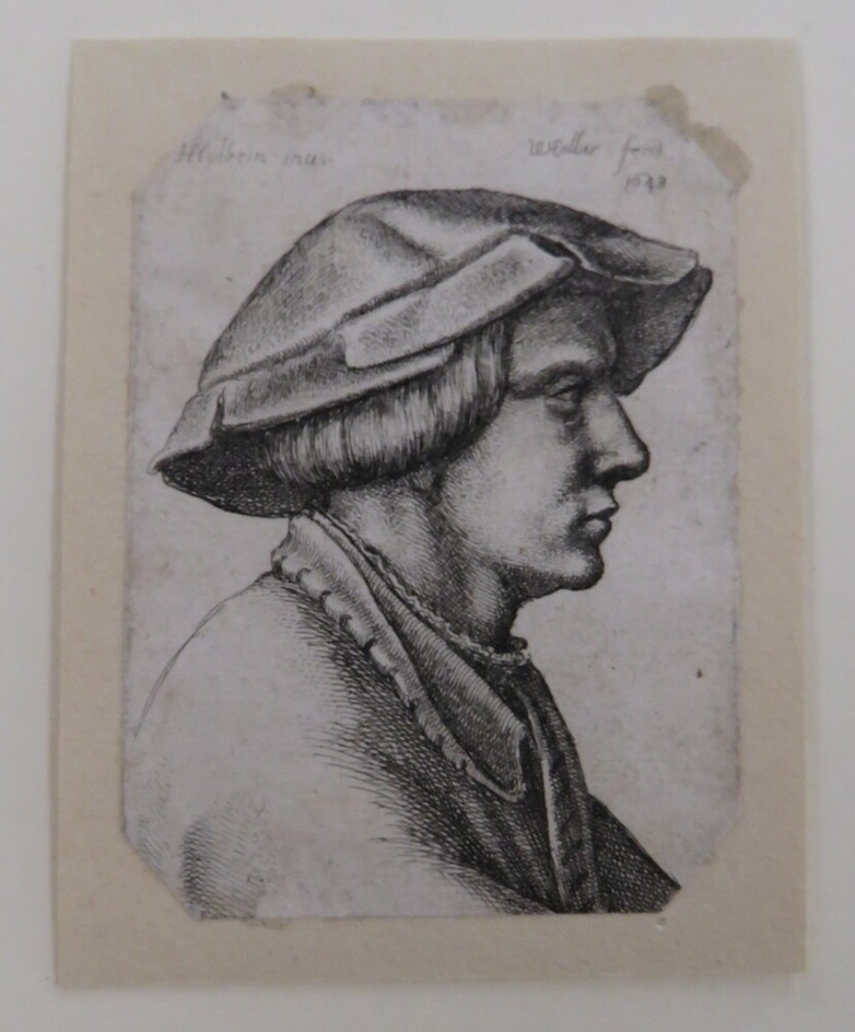 Head of a young man wearing hat in profile to right